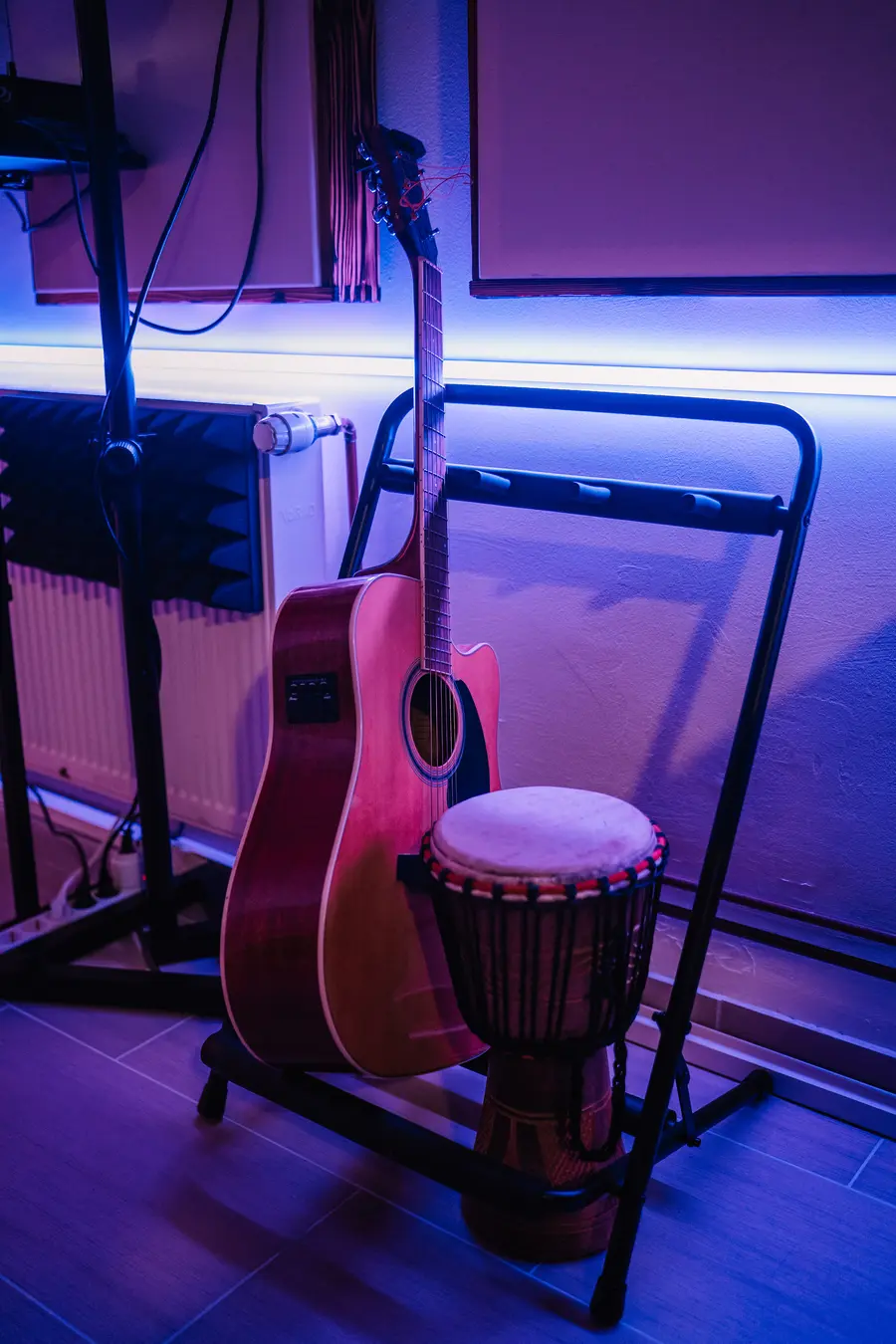 An acoustic guitar and a djembe under blue LED light